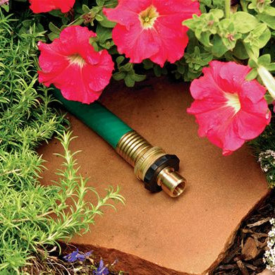 Brass Quick Connect Hose Fitting Set - image of the product on a garden hose surrounded by plants
