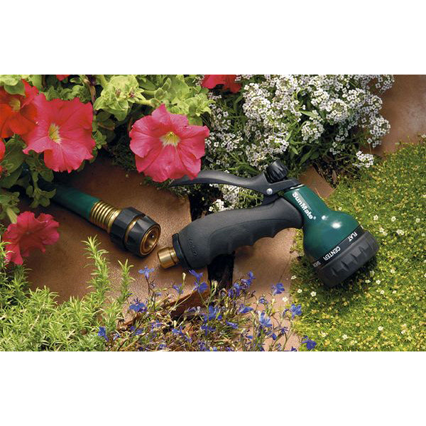 Brass Quick Connect Hose Fitting Set - image of the product on a garden hose surrounded by plants and facuet