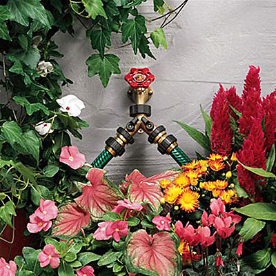 Brass Hose Y with Shut Offs: an image of the product being used on a faucet surrounded by plants