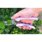 ARS 130DX Bypass Pruner - Violet pruning shears are being used to cut plants outdoors.