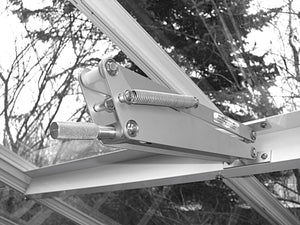 The Bayliss Triple Spring Solar Vent Opener is closing the roof of a greenhouse.