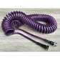 Coiled Garden Hose – 3/8” ID: Image of the purple coiled garden hose on a wooden table