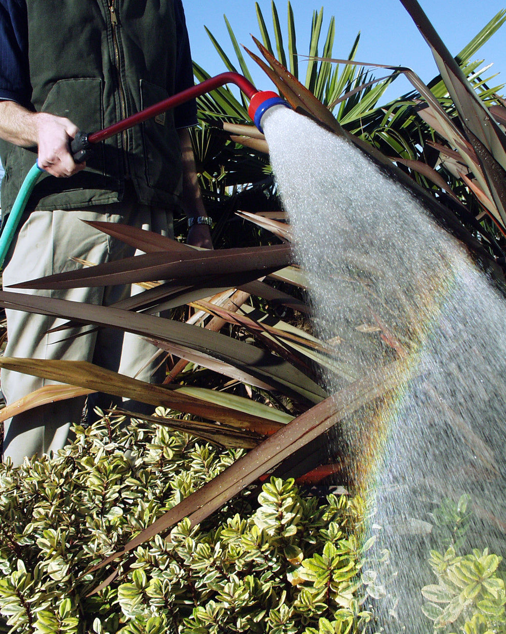 Dramm Ultra Soft Water Nozzle being used in a garden outside