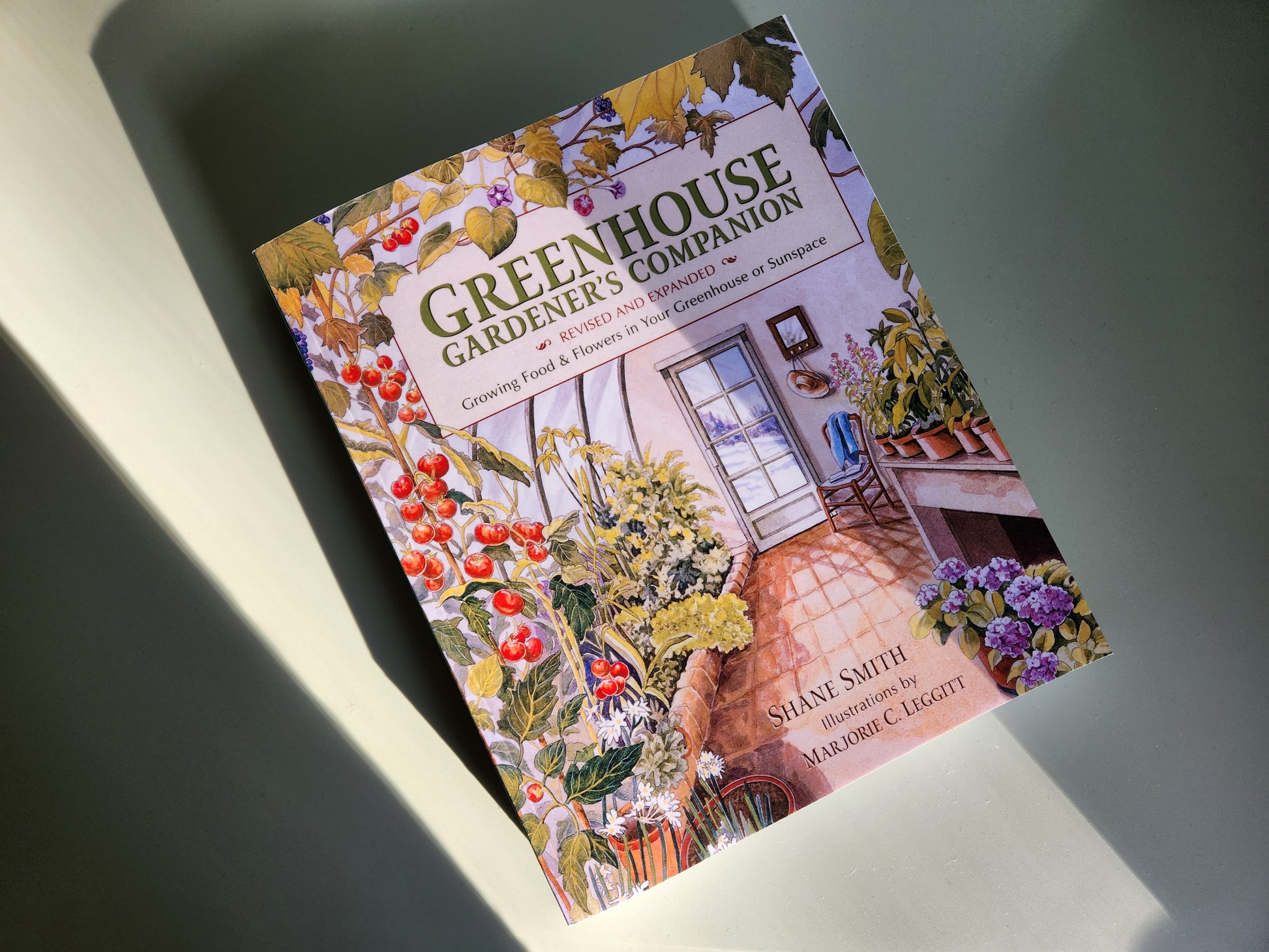 Greenhouse Gardener's Companion by Shane Smith - image of the book on a flat green surface