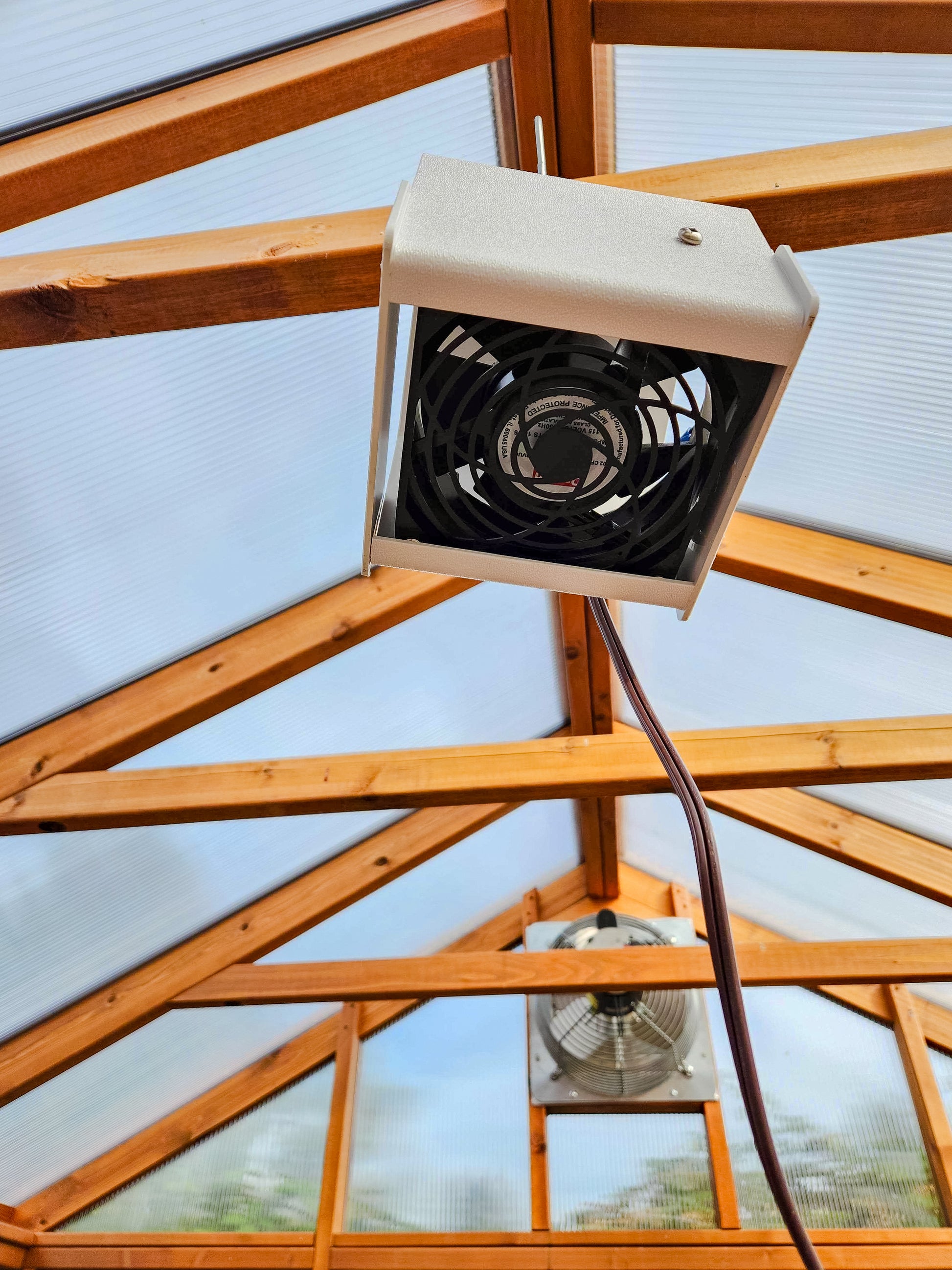 Heat Saver Fan: A bottom view of the product hanging in a greenhouse.