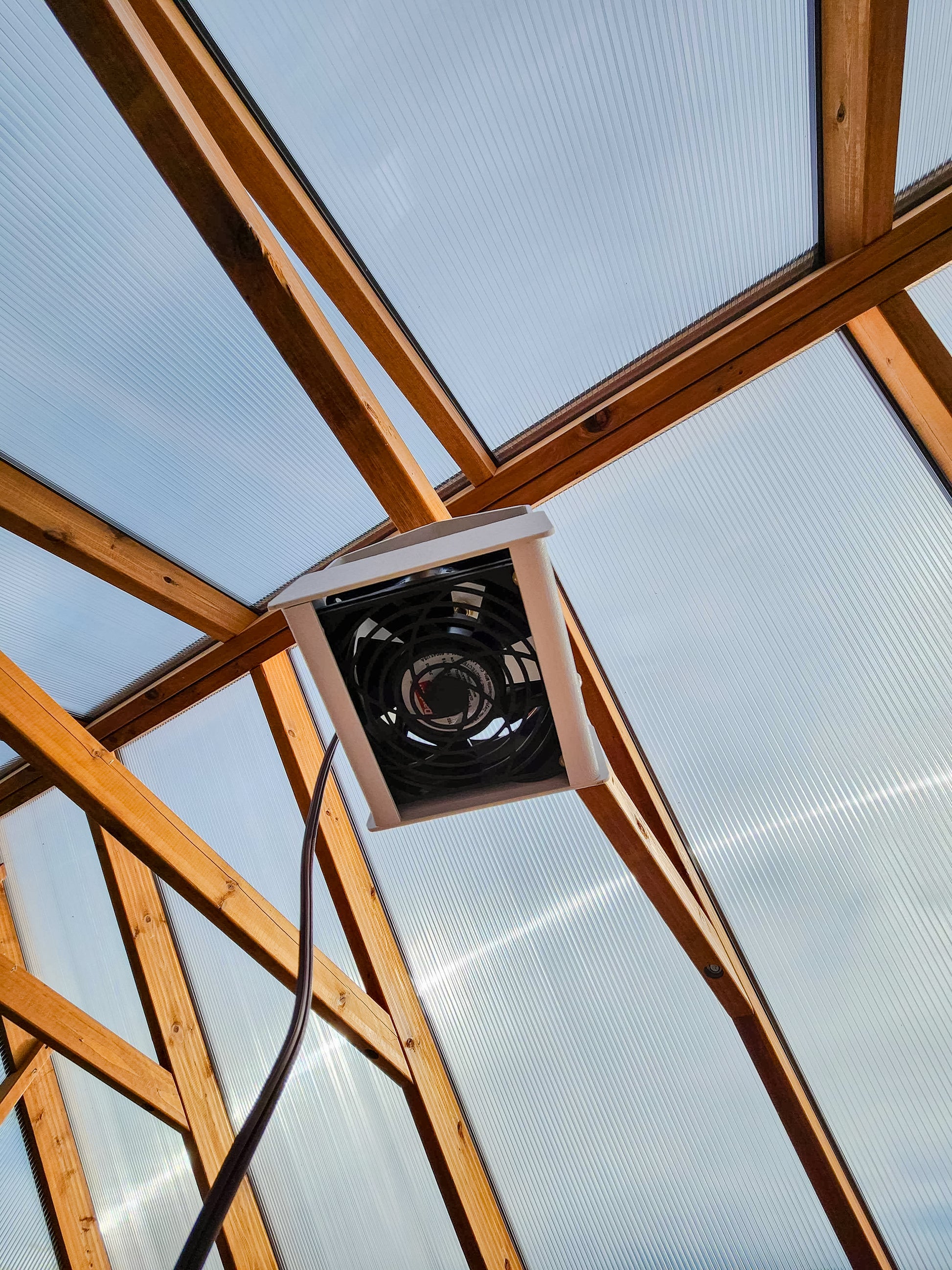 Heat Saver Fan: A bottom view of the product hanging in a greenhouse.